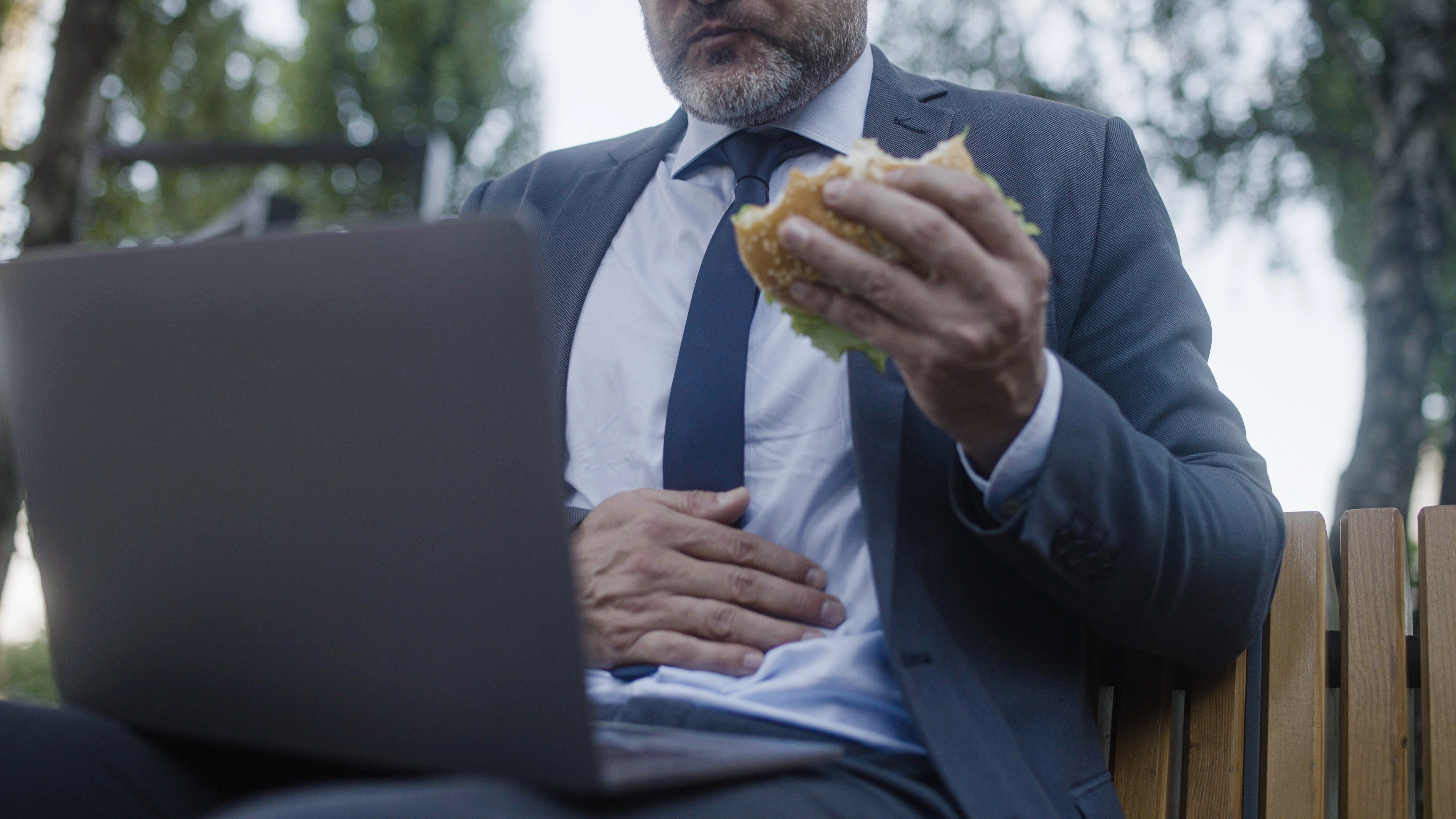 A man holding his stomach while eating